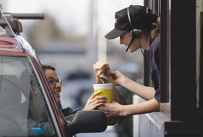 a fast-food employee gives a customer her order
