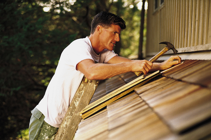 Man installing roof shingles