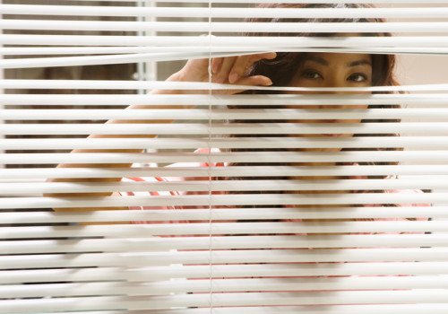 Inquisitive woman looking through window blinds