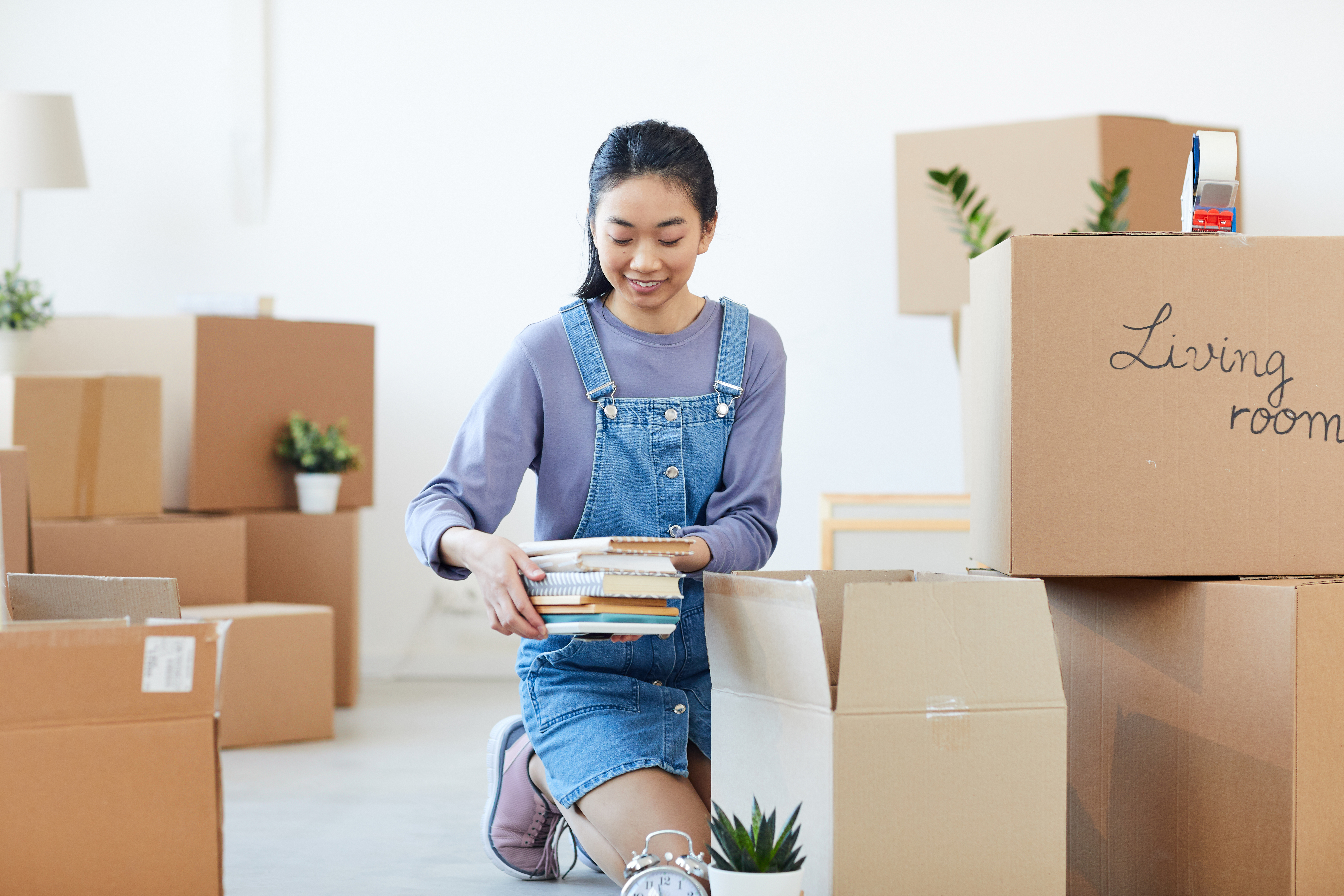woman packing books in moving boxes