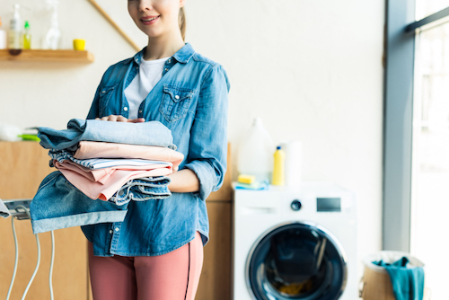 woman holding clean clothes at home