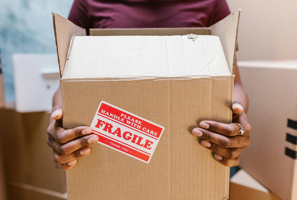 Woman holding cardboard box with fragile label on it