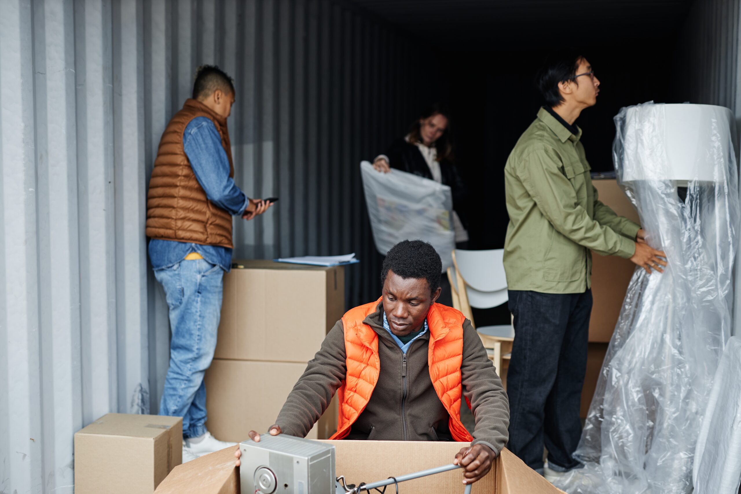 a group of people inspecting items in an abandoned storage unit